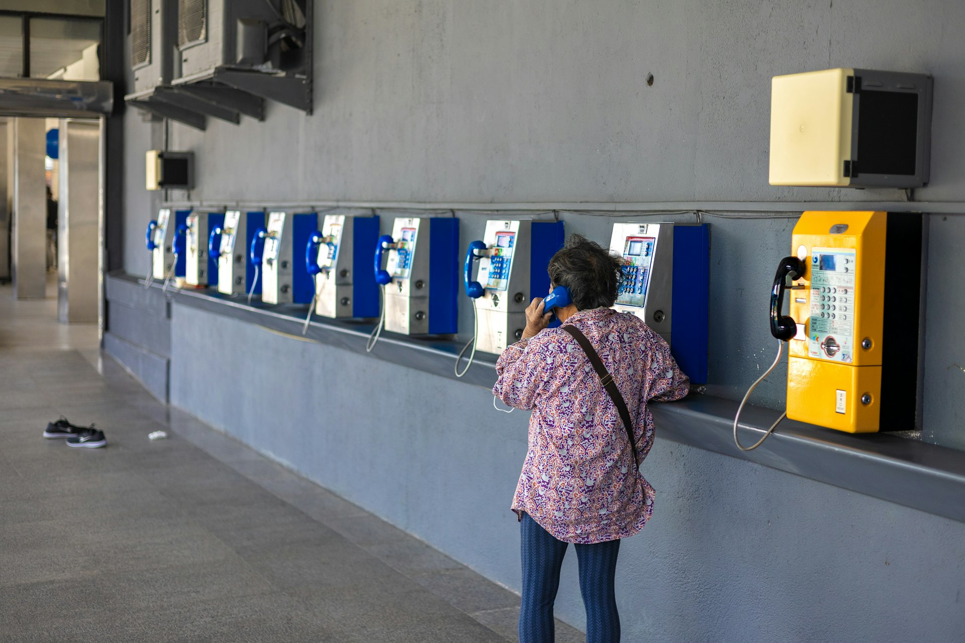 A person uses one of the public payphones.